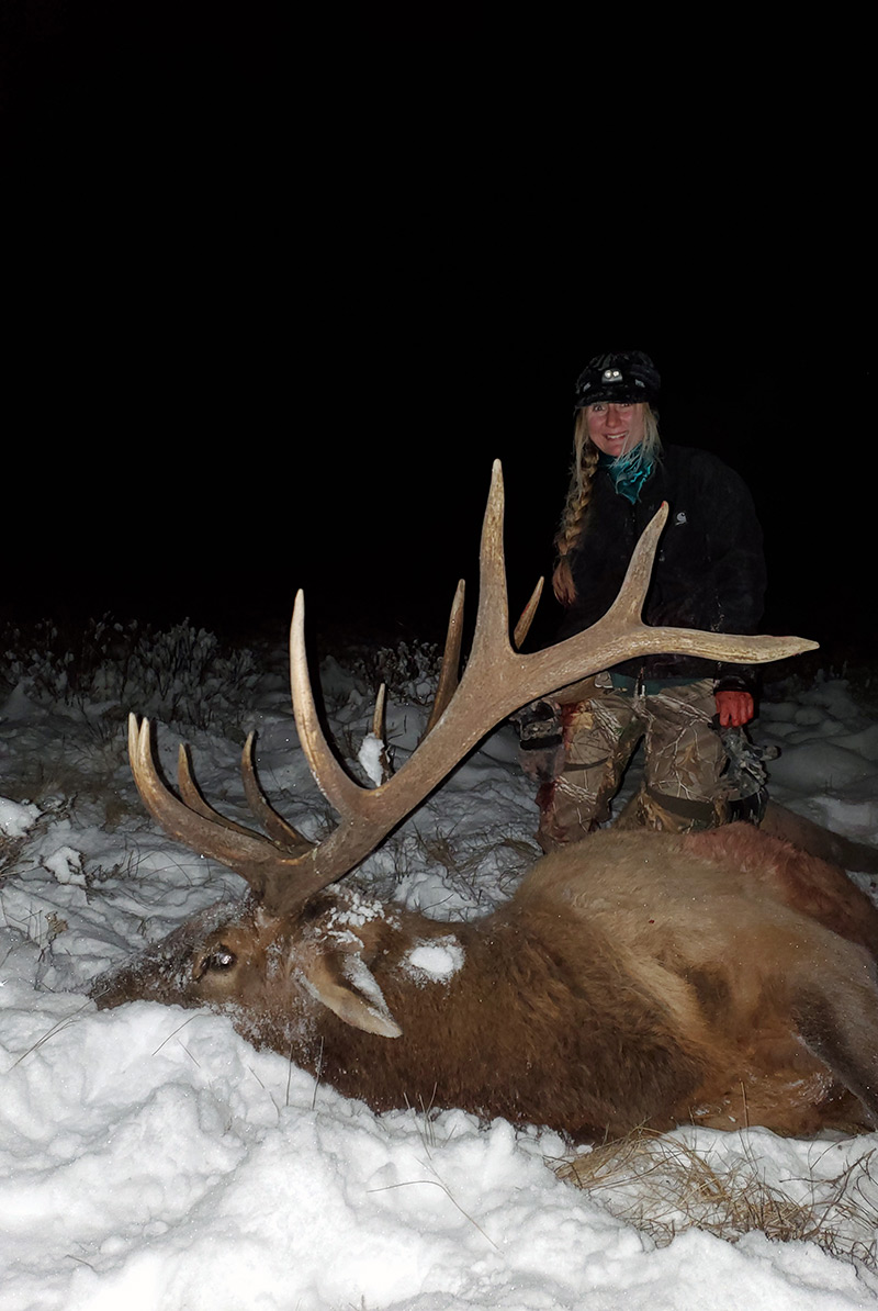 Kelsey standing with her elk harvest.